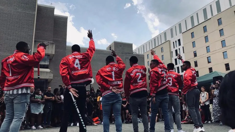 Kappa Chi Brothers stepping in crimson jackets